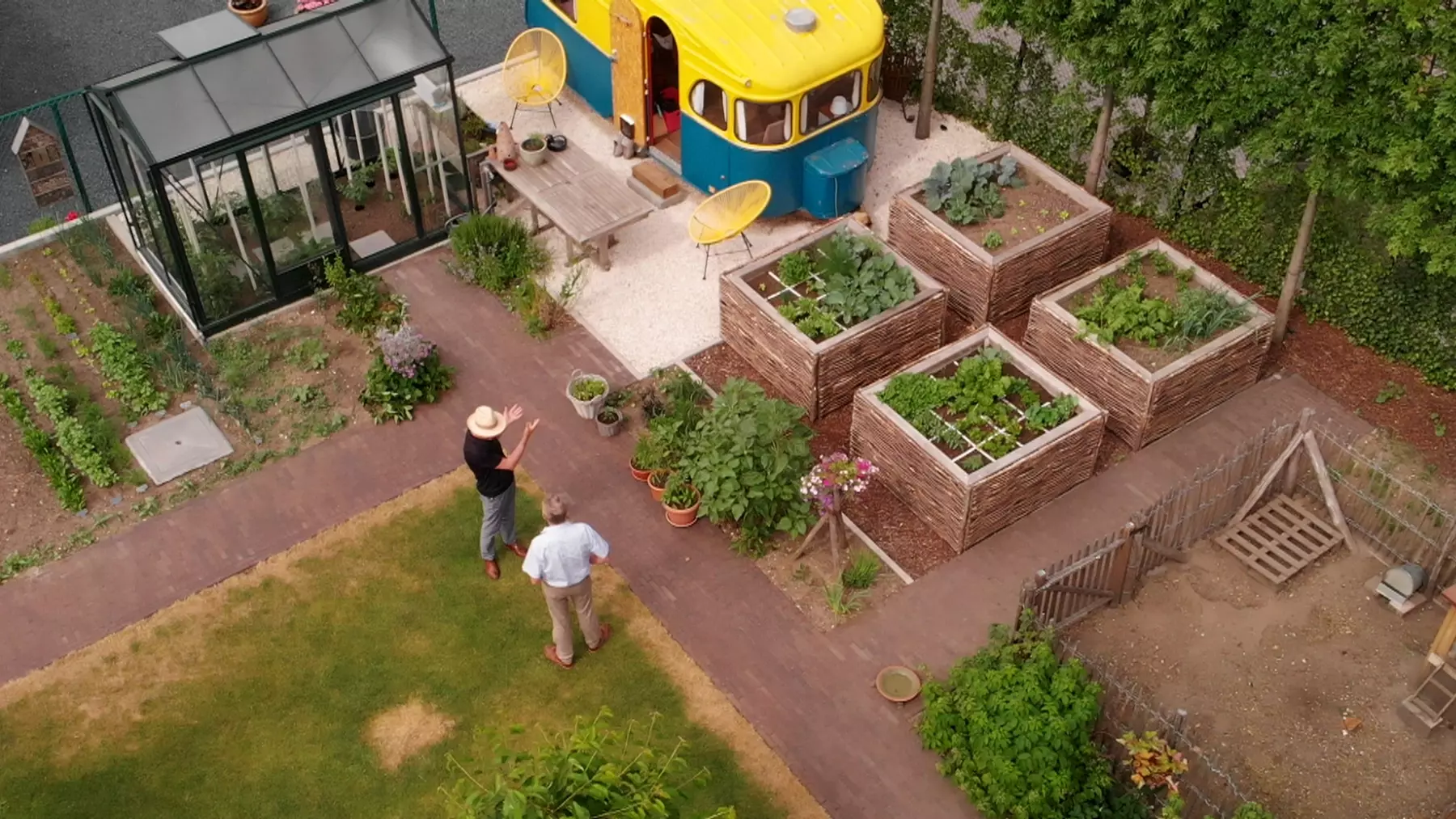Adviseur toont verschillende tuintypes op locatie bij een Vlaamse woning